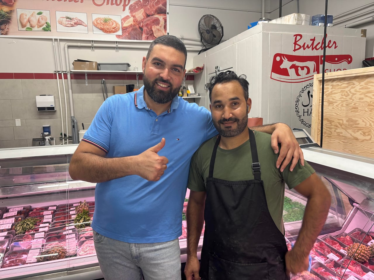 two men in front of butcher counter