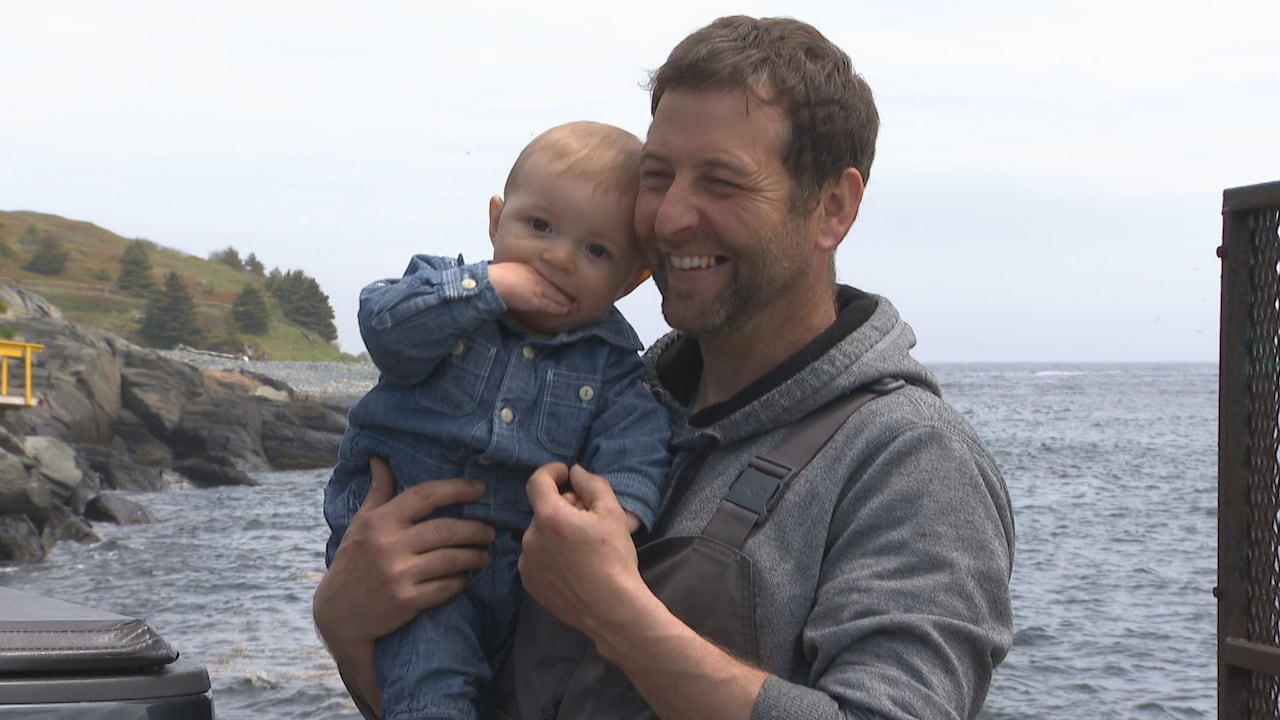 Man holds baby smiling