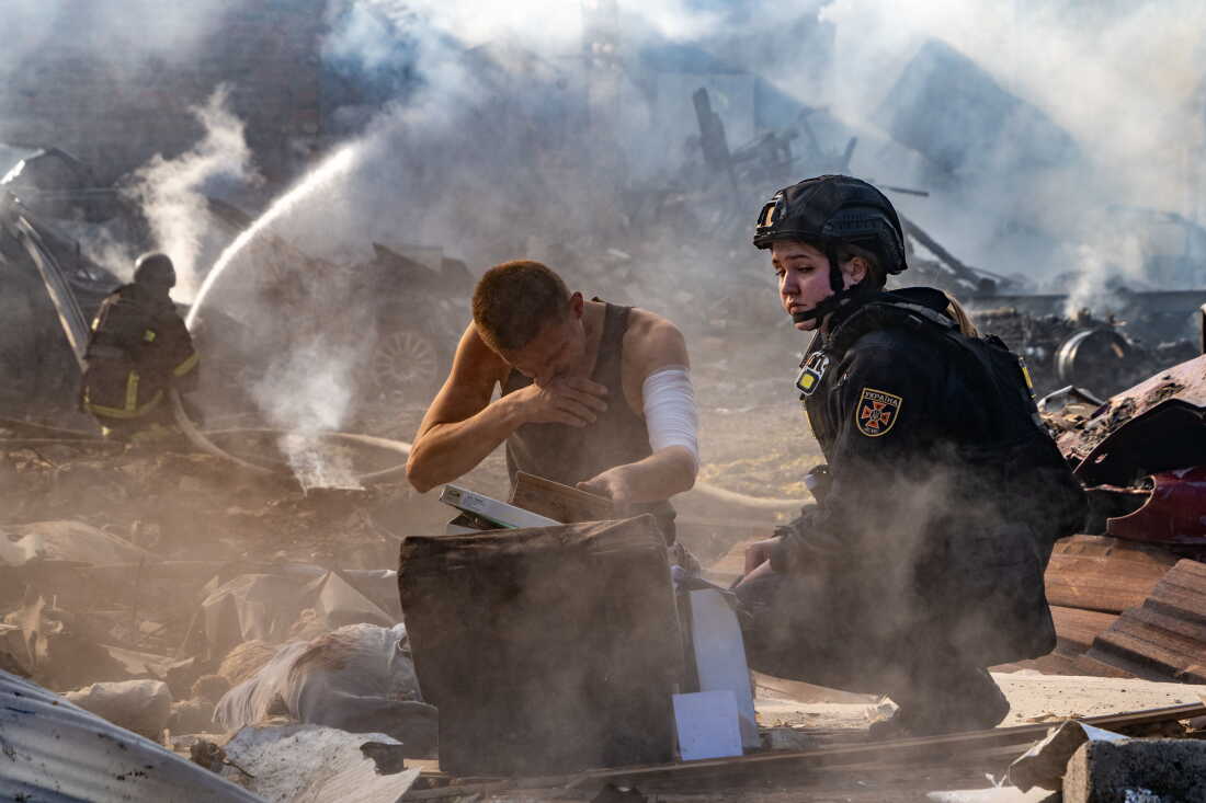 An injured man collects his personal belongings in front of his house destroyed in a Russian strike on Kharkiv, Ukraine, Sunday, Oct. 11, 2026.