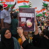 A protester holds a placard after India's Education Minister Dharmendra Pradhan resigned following nationwide protests as part of the Cockroach Janta Party's protest movement in Mumbai, India on Saturday.