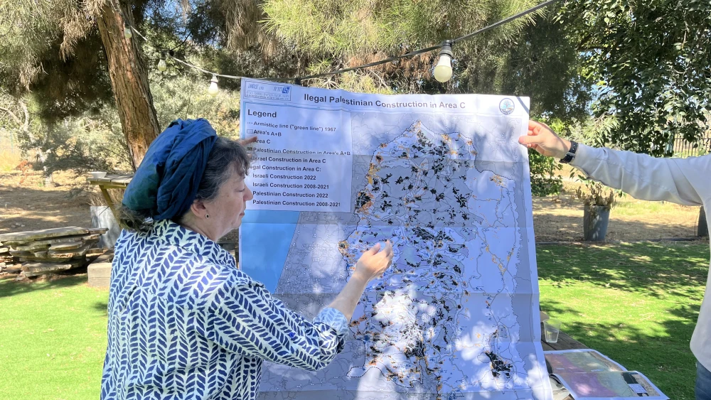 Naomi Kahn, director of Regavim’s International Division, points to illegal Palestinian Authority construction on a map during a tour in the southern Hebron Hills, July 14, 2026. Photo by Josh Hasten.