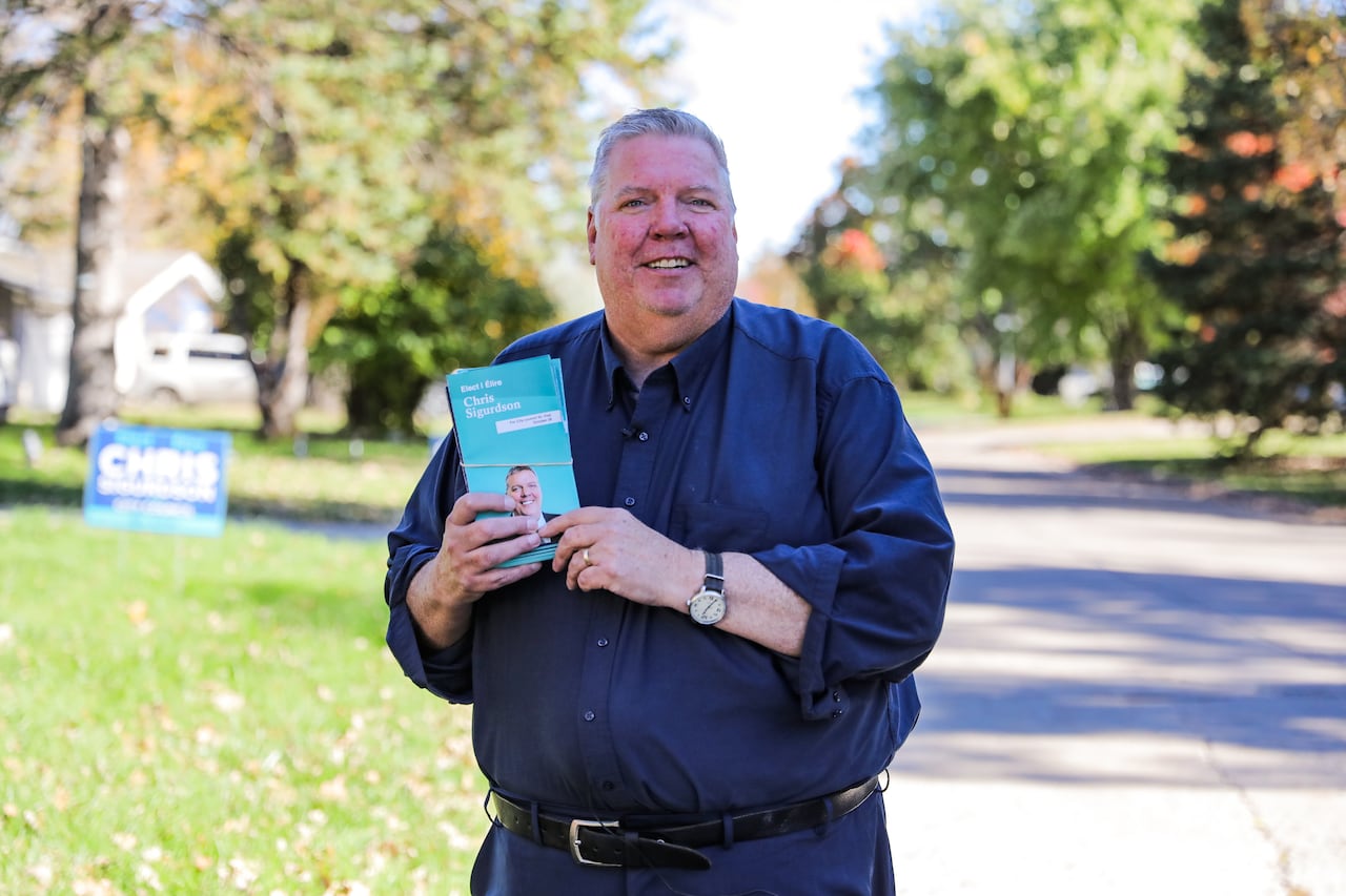 A man holding up election pamphlets.