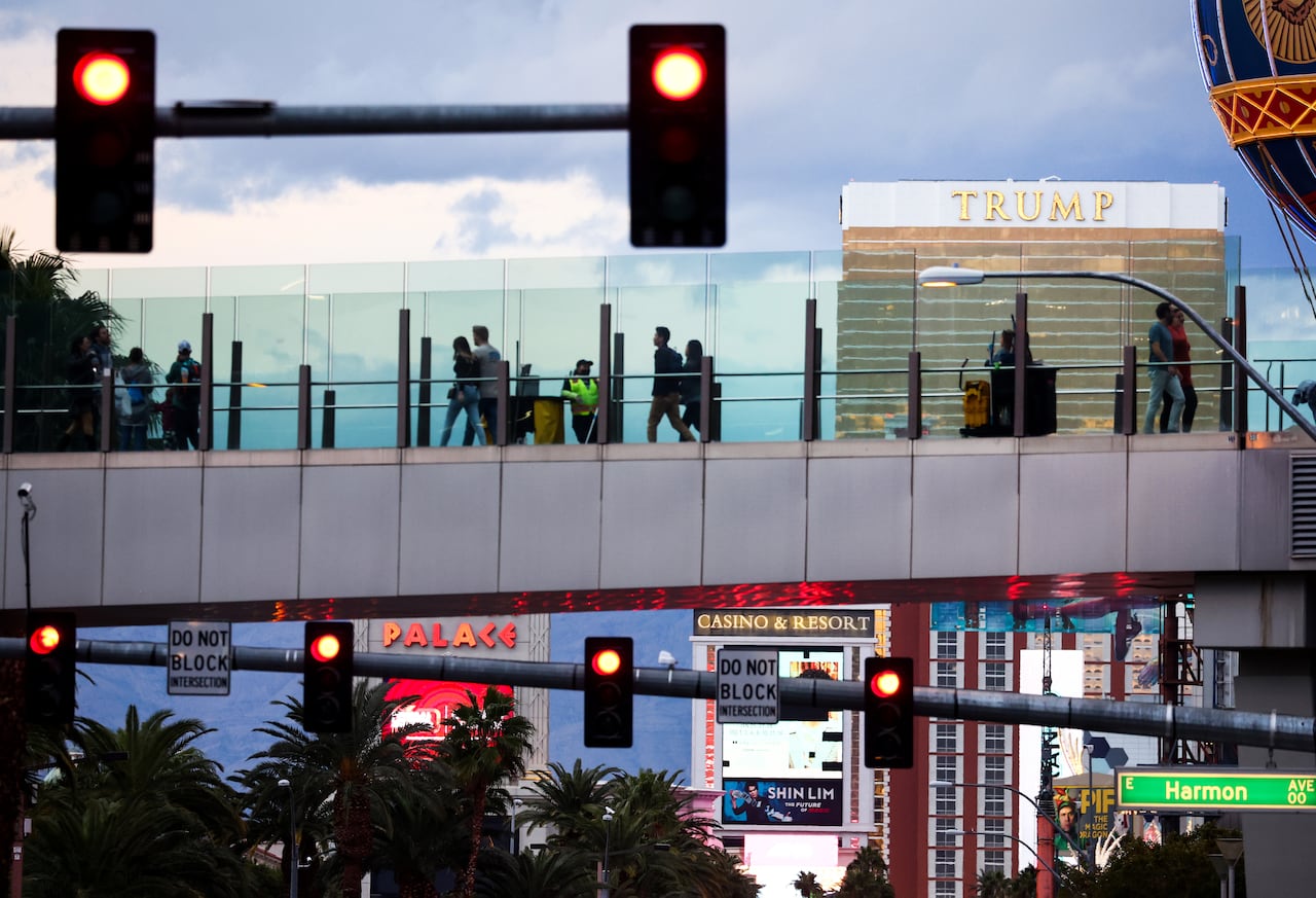 Pedestrians cross an overpass along the Las Vegas Strip with the Trump International Hotel visible in the background. Nevada Democrats are trying to capitalize on the economic carnage Trump inflicted on the gambling mecca by starting a trade war with