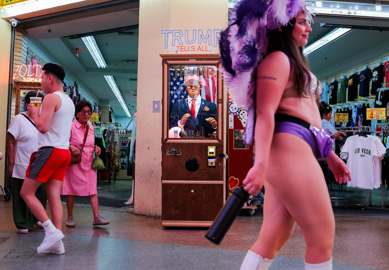People walk along Fremont Street Experience past an animatronic Donald Trump fortune-telling machine modeled after the classic Zoltar arcade figure on June 09, 2026, in Las Vegas, Nevada.