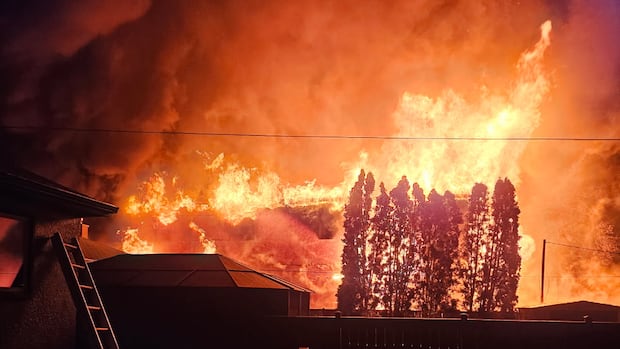 Neighbours use garden hoses on homes as fire destroys multiplex under construction in Winnipeg