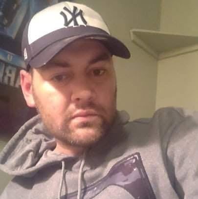 A man with a baseball cap on.