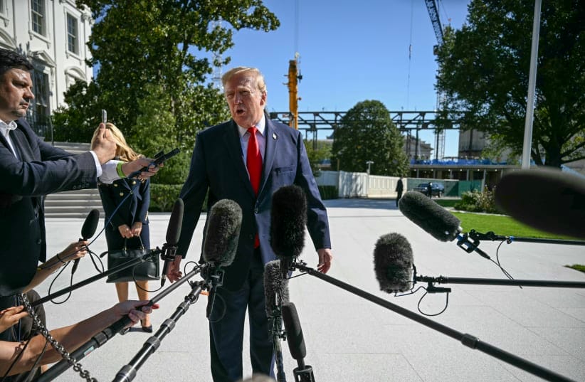 US President Donald Trump talks to members of the press before boarding Marine One as he departs from the South Lawn of the White House in Washington, DC, on October 13, 2026.