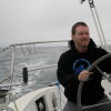 Sailor Matt Rutherford at the helm of a sailboat. He hopes to be the first to circumnavigate the Arctic Circle alone.