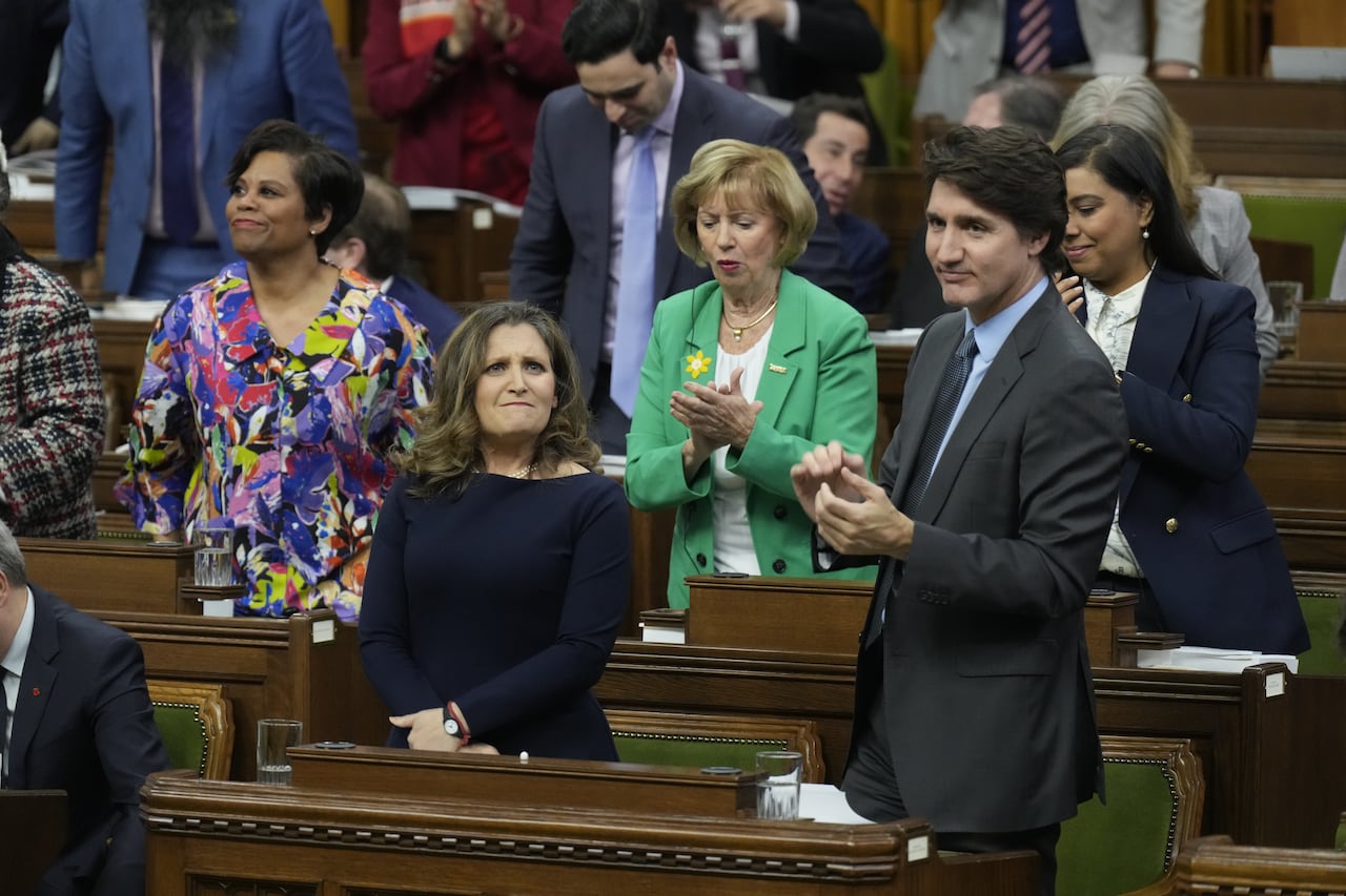 Freeland stands in the House as Trudeau and other Members of Parliament applaud.