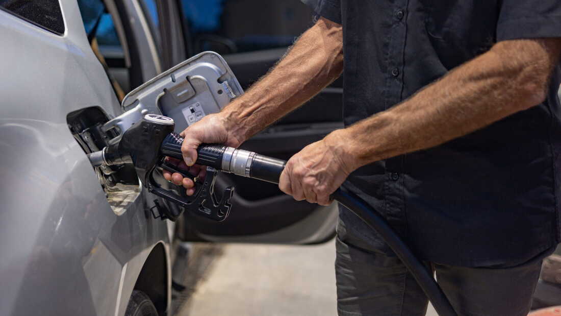 A man pumps gas at a gas station.