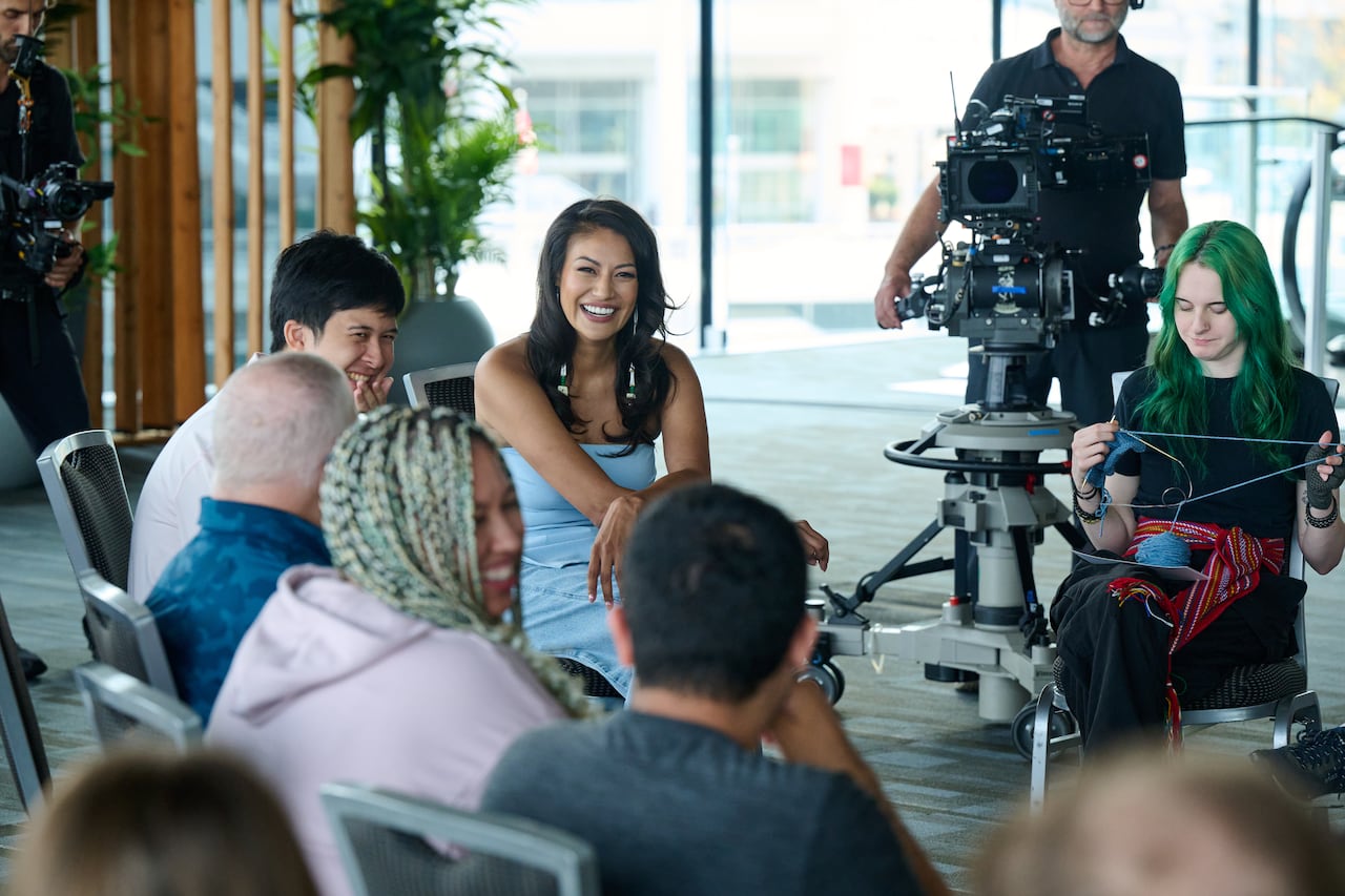 Woman laughs amongst group of people.