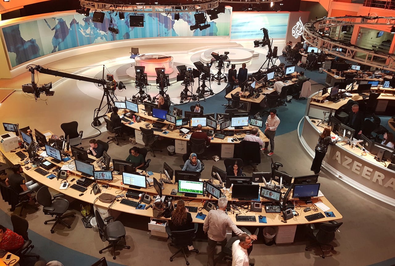 A view of people working in the Al Jazeera television newsroom.
