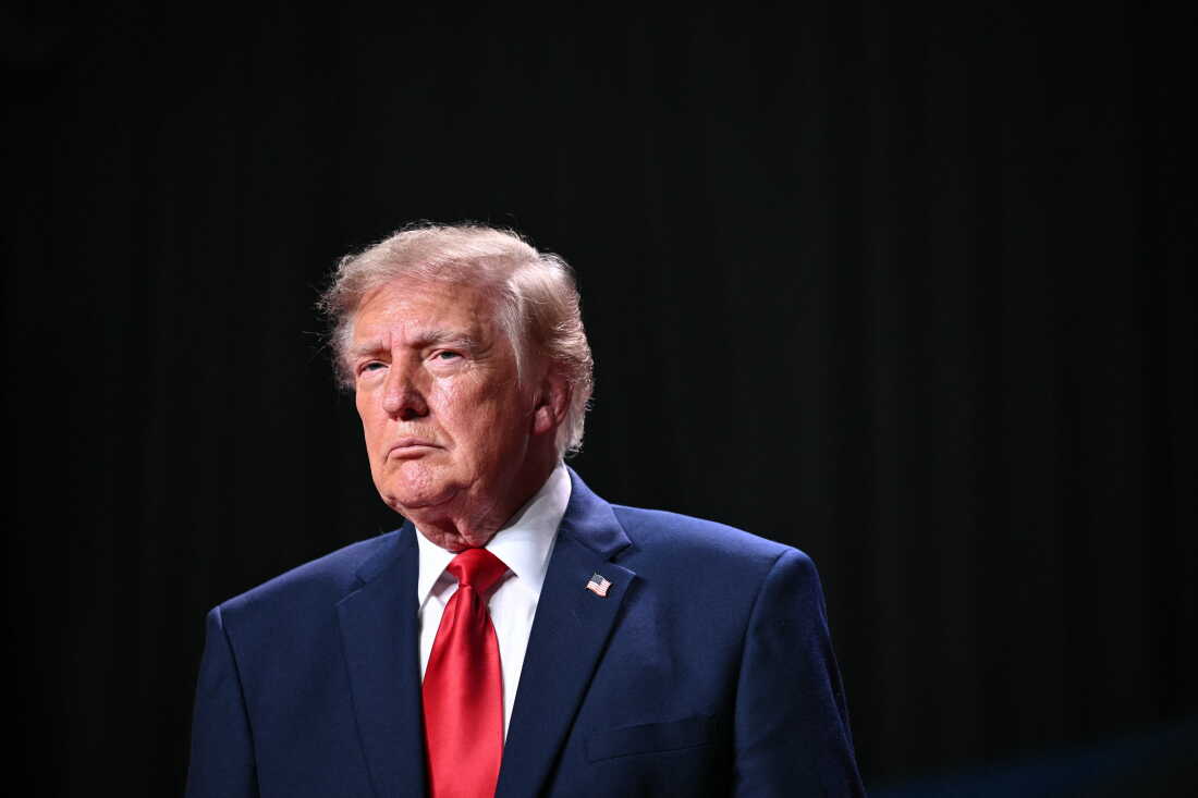 President Trump speaks at a campaign rally in San Antonio on October 7, 2026. He's wearing a blue suit and red tie.