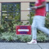 A person walks past a voting sign at the East Point Library on Tuesday, the first day of early voting, in Atlanta.