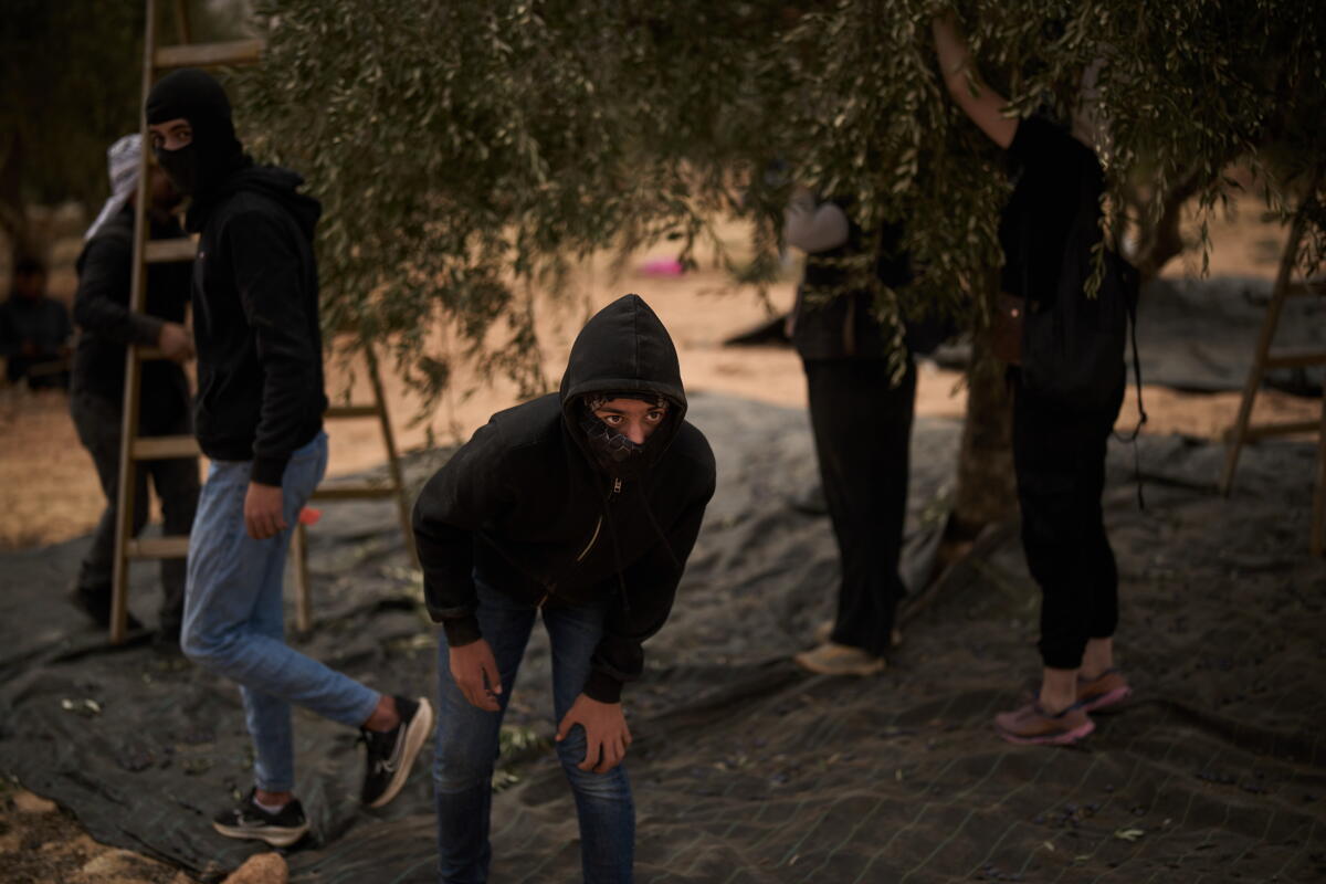 A Palestinian youth observes the movement of the Israeli forces