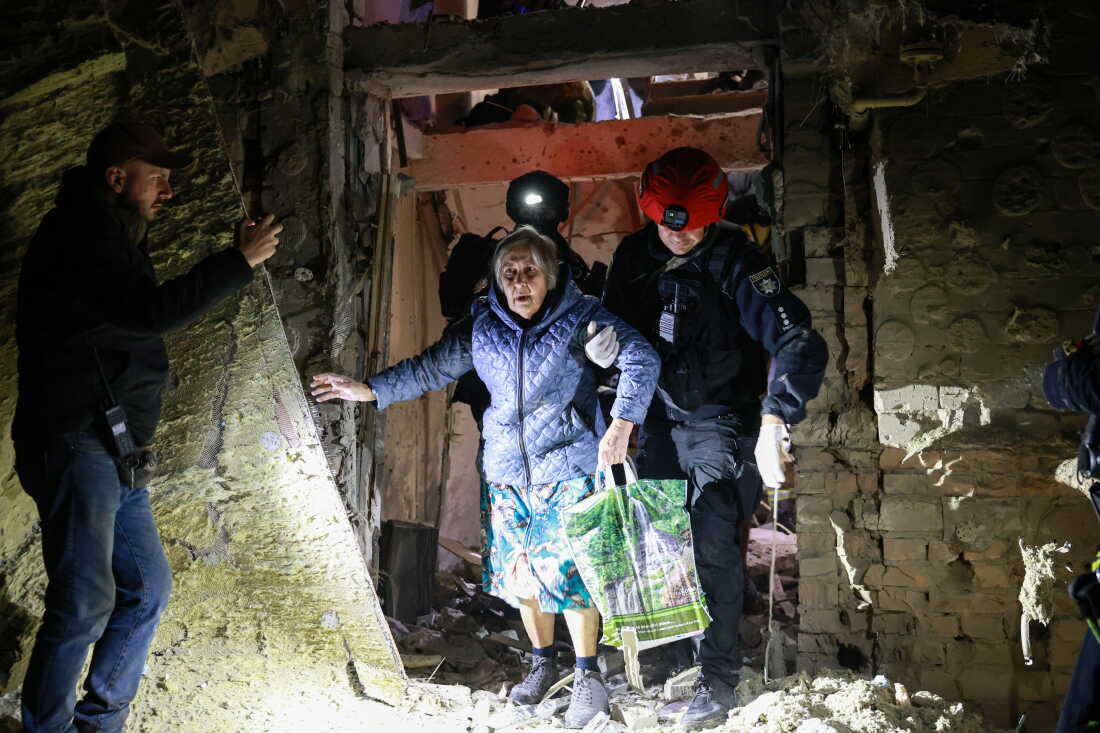 A policeman helps an elderly woman to walk out from a residential building damaged by a Russian airstrike in Zaporizhzhia, Ukraine, on Saturday.