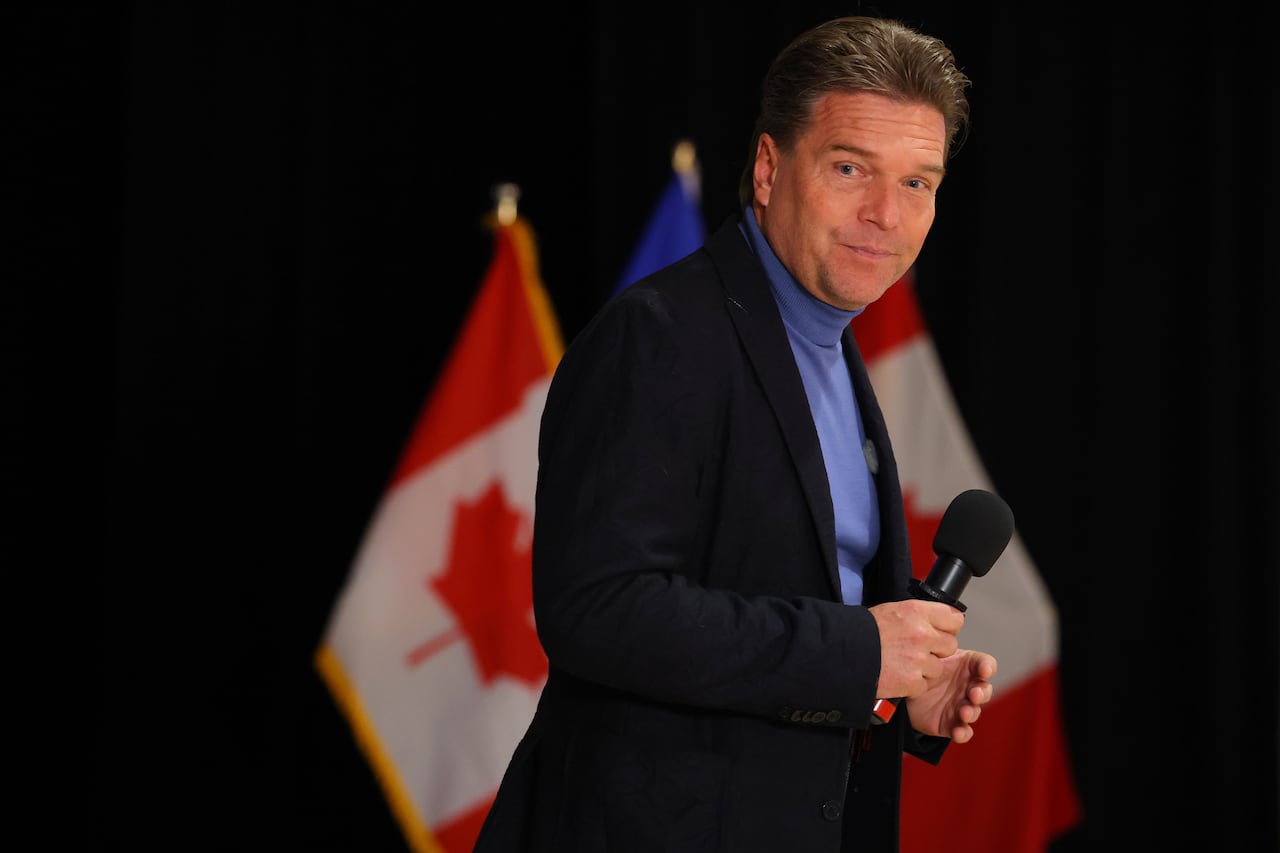 A man stands in front of a Canadian flag.