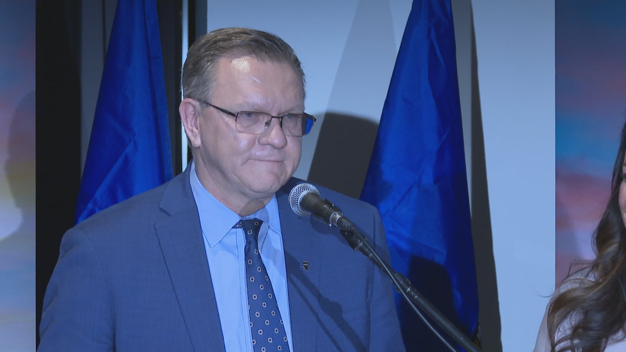 A man speaks behind a microphone.