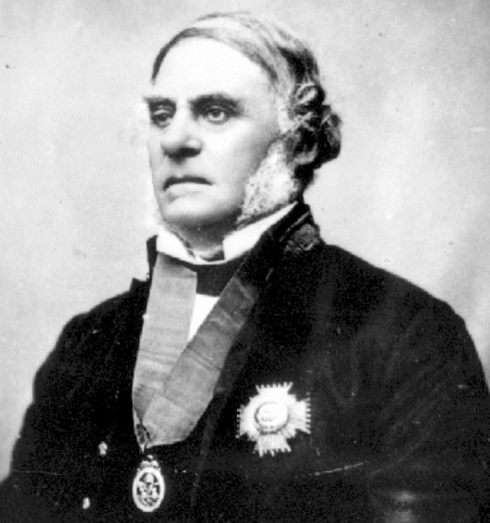 A black and white photo of man from the 1800s with a medal around his neck.