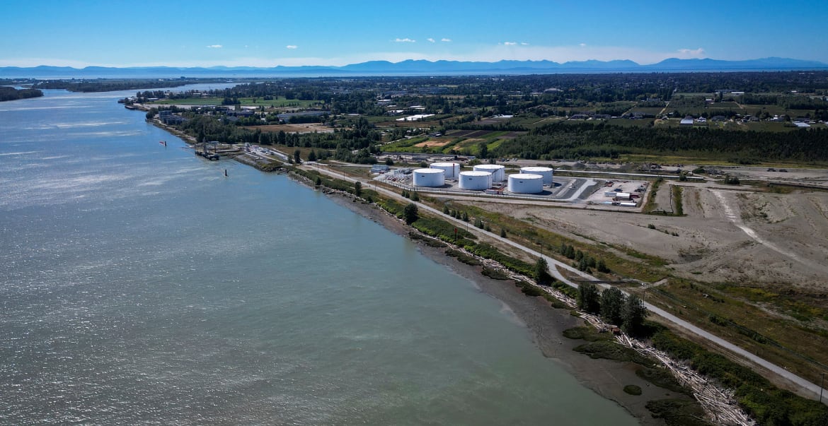 An aerial photo of water and farmland, with mountains in the background.