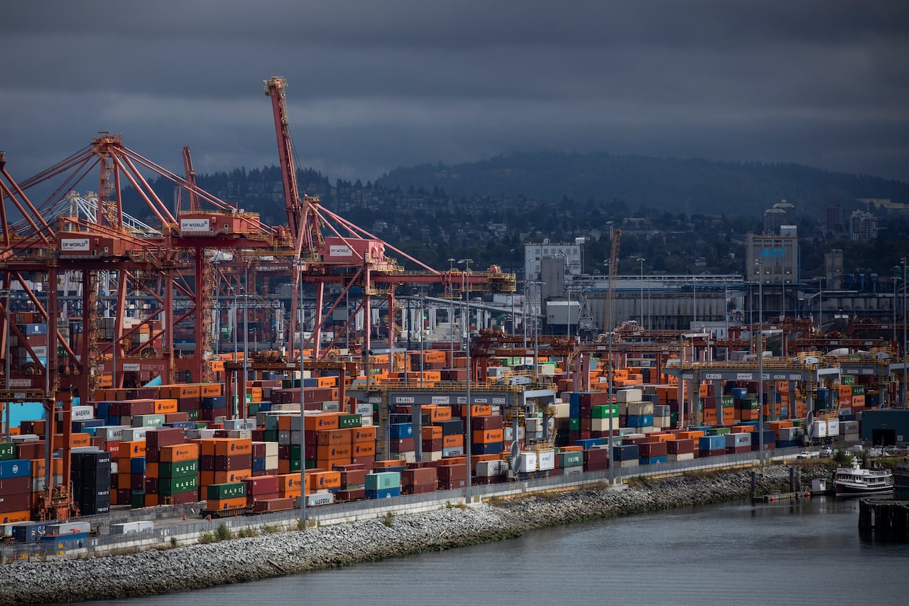 Colourful cargo containers are pictured under cranes at the Port of Vancouver.