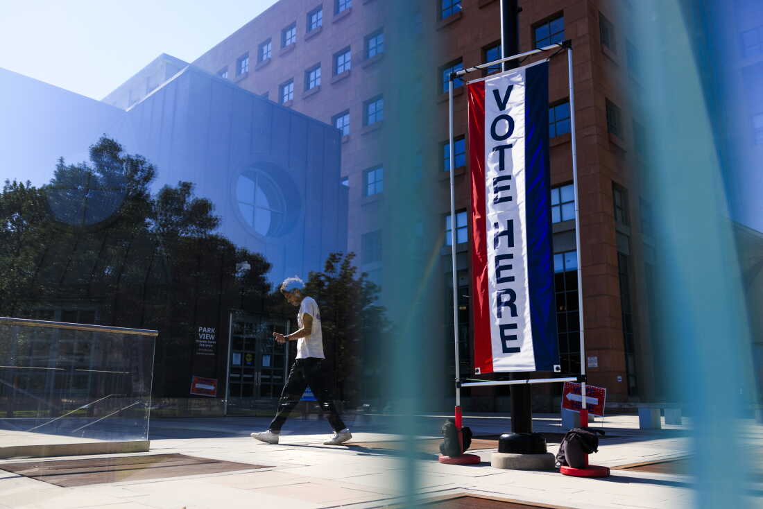 People walk by a polling place at Denver's Central Library on June 30, 2026.