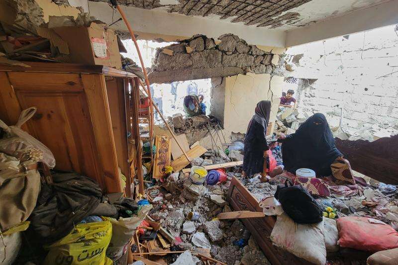 Residents walk on their home debris at Seina district in Taiz, Yemen, after a missile strike, Tuesday, Oct. 20, 2026. (AP Photo/Marzouq Al Jabri)
