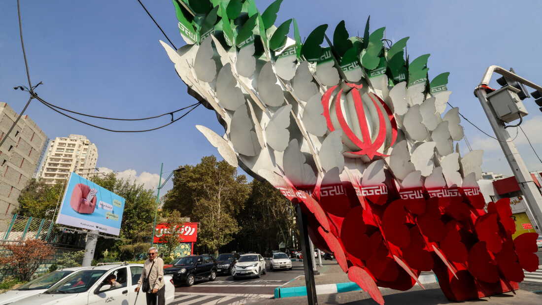 Traffic in Tehran on Wednesday moves past an installation depicting butterflies forming the Iranian national flag.