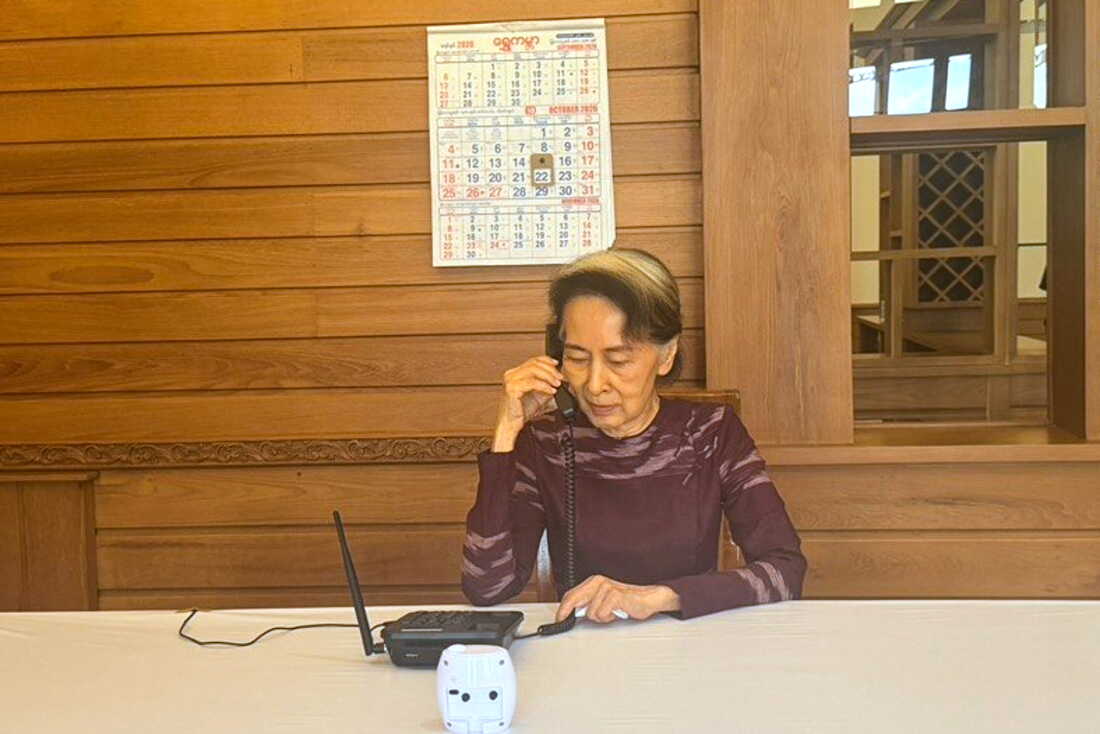 In this photo released by Myanmar's government on Thursday, Myanmar's ousted leader Aung San Suu Kyi talks on the phone with her son Kim Aris, in Naypyidaw, Myanmar.
