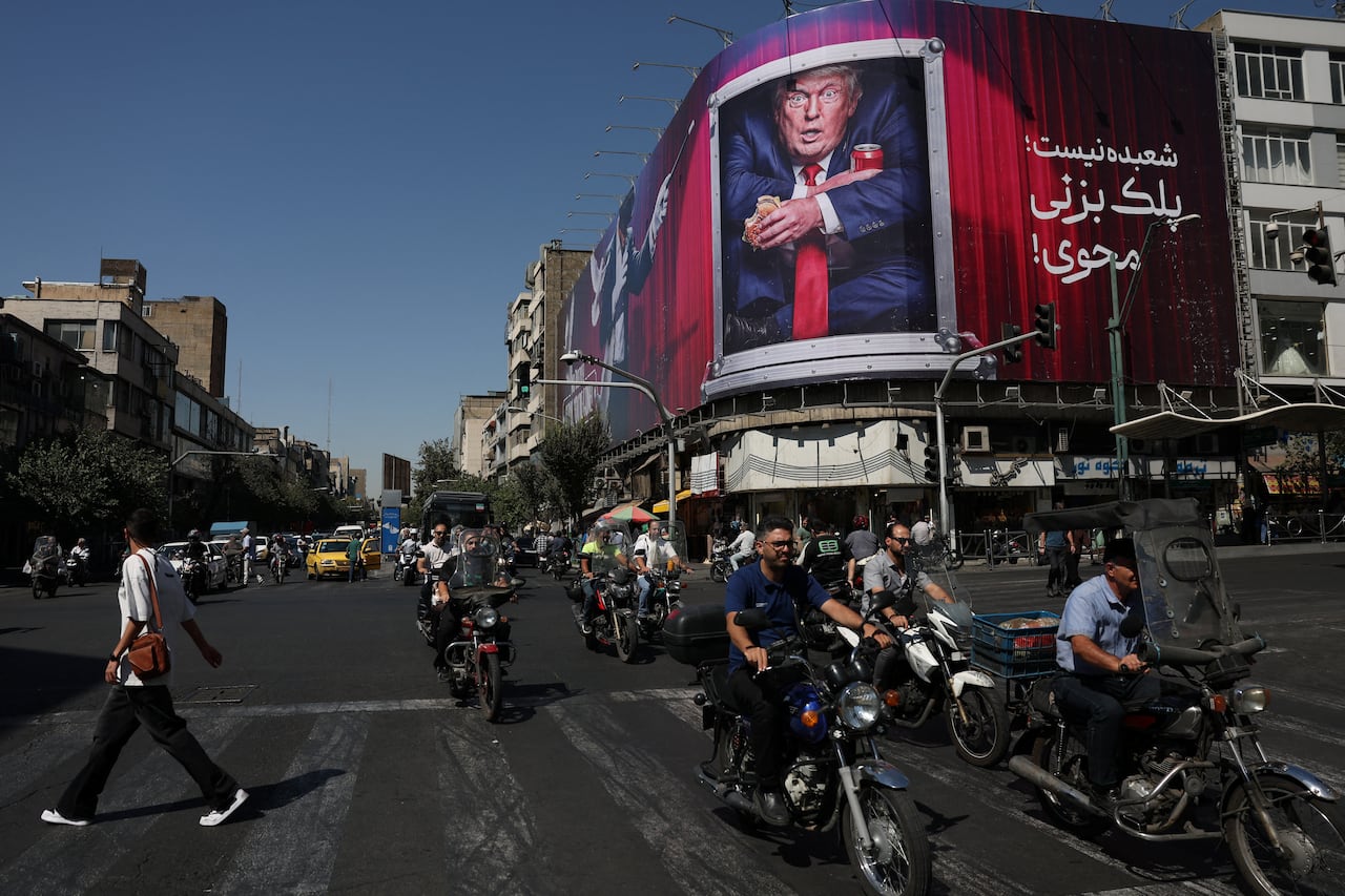People drive near a billboard depicting U.S. President Donald Trump on a building in Tehran, Iran, September 16, 2026.