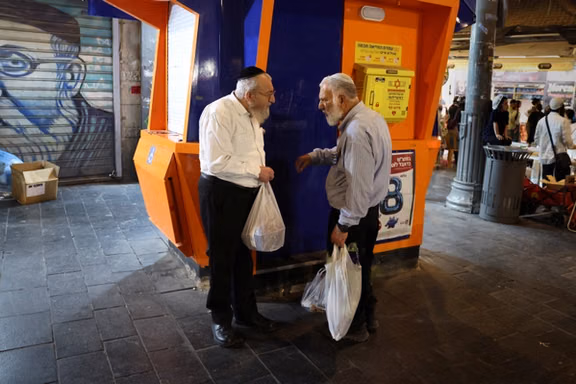 Two men speak on Jaffa Street, one of the main shopping streets, ahead of the Israeli parliamentary election in Jerusalem, October 22, 2026.
