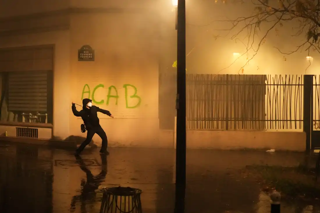A protester throws a projectile towards police after a demonstration against rising living costs in Paris, Saturday, Oct. 24, 2026.