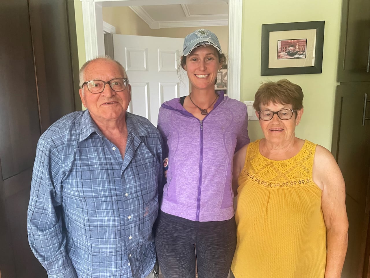 A woman, 30, posted between an elderly couple