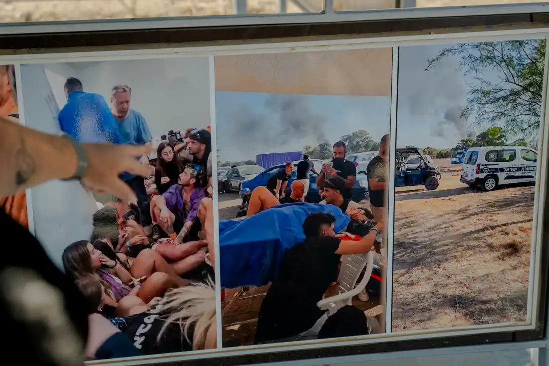 Meir Zohar points to documentary photographs displayed on an informational board at the Nova festival memorial site near Kibbutz Re'im, southern Israel, on Sept. 24, 2026. The center photograph shows his wounded daughter, Bar Zohar, receiving emergency treatment on a makeshift table in the final minutes of her life before succumbing to her injuries after Hamas militants attacked the music festival on Oct. 7, 2023.