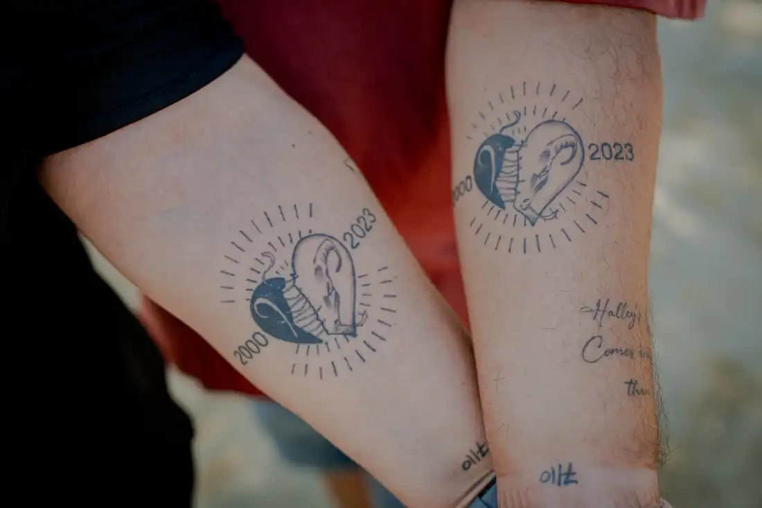 Meir and Kati Zohar display matching memorial tattoos on their forearms at the Nova music festival memorial site near Kibbutz Re'im, southern Israel, on Sept. 24, 2026. The tattoos feature the birth year and zodiac sign of their daughter, Bar Zohar, who was killed when Hamas militants attacked the music festival on Oct. 7, 2023.
