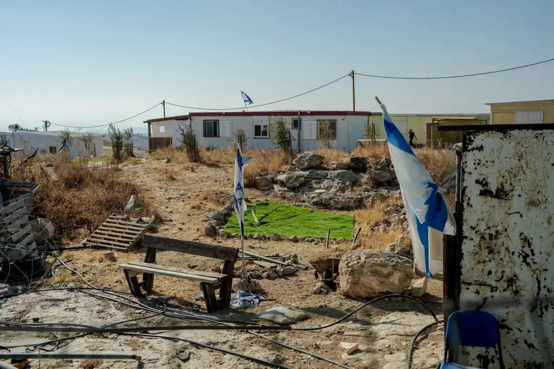An Israeli flag erected by settlers is seen through the window of the home of Ikhlas al-Hathaleen in the Palestinian village of Umm al-Kheir, in the Masafer Yatta region of the Israeli-occupied West Bank, on Sept. 24, 2026. Military closure orders have restricted the family from accessing their courtyard toilet and sheep pen.