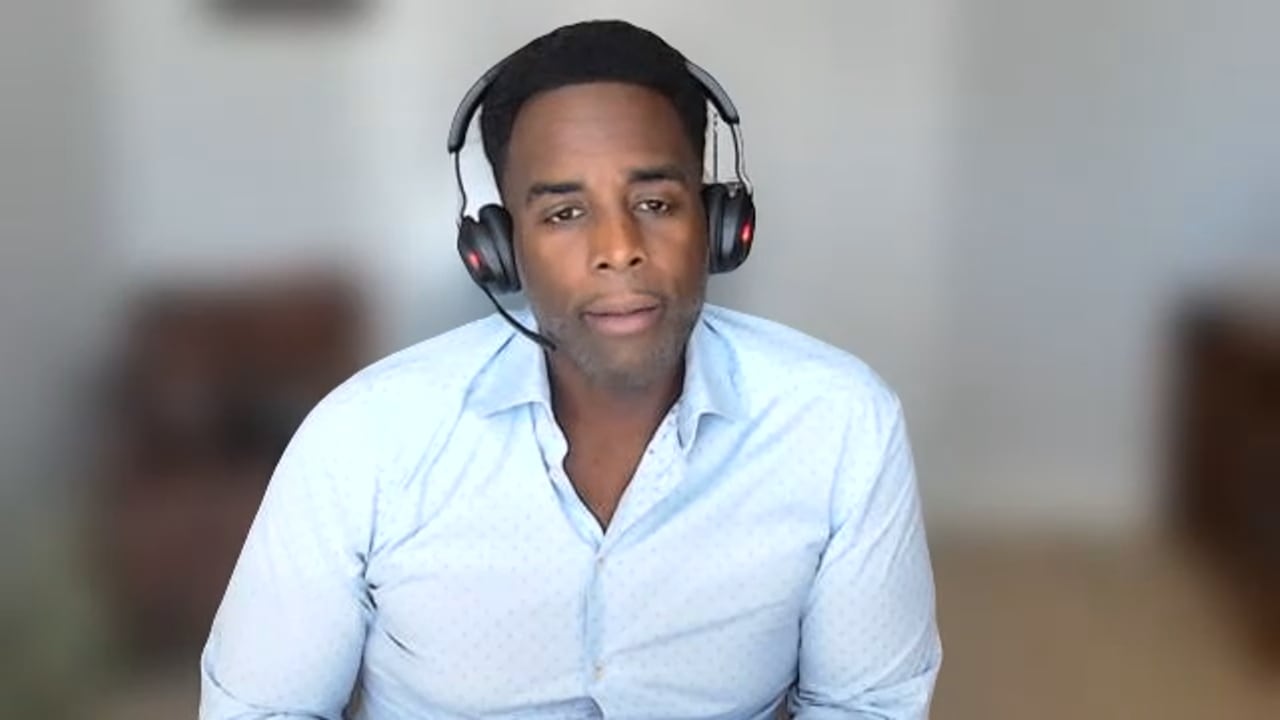 A man in a blue shirt is pictured during a Zoom call.
