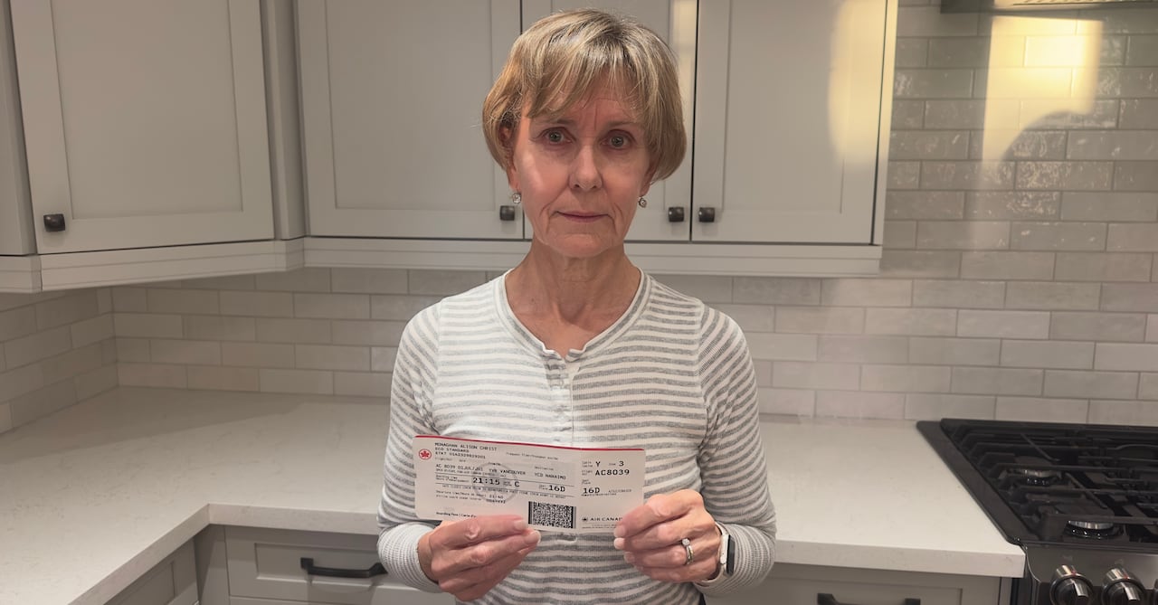 Woman standing in kitchen holding an Air Canada boarding pass