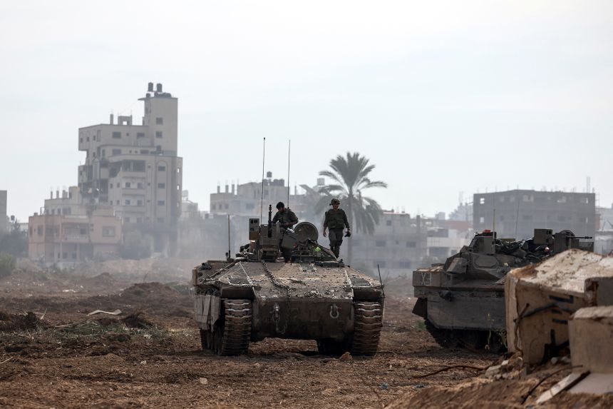 Israeli soldiers stand on an Israeli armoured personnel carrier as they operate in Gaza on January 8, 2024.