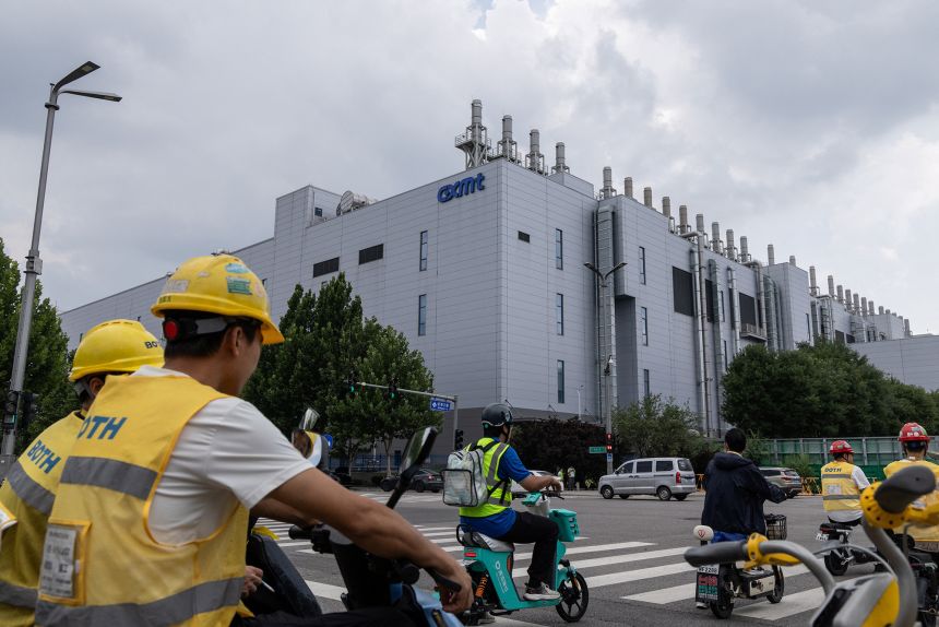 People ride electric bikes next to a production facility of China's top memory chipmaker CXMT in Beijing, China, on July 29, 2026.