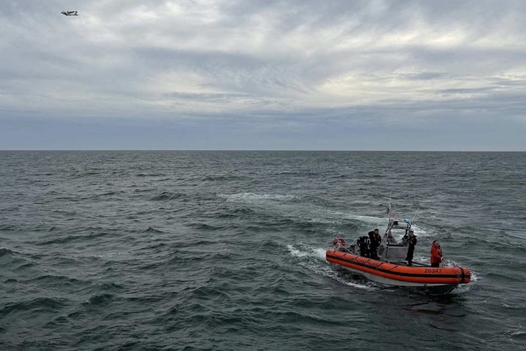 US Coast Guard members search for people after it found debris from a medical transport aircraft off the shore of Massachu...