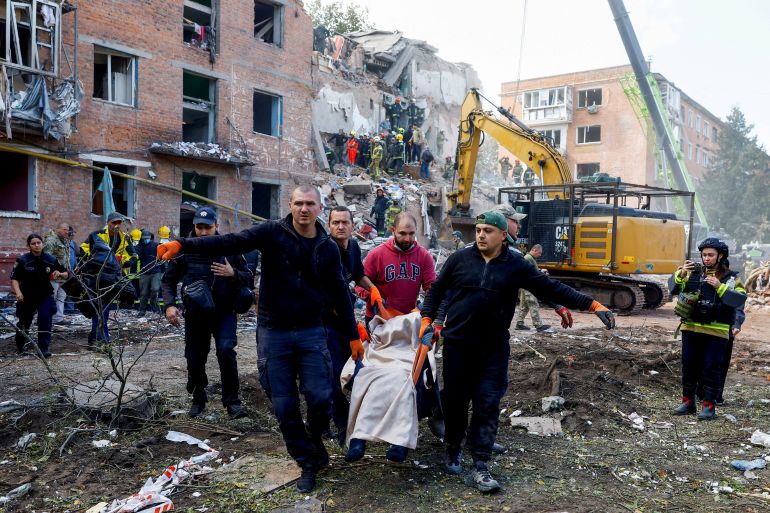 People carry a casualty, as emergency services work to rescue residents from under the debris at the site of an apartment building which was hit by a Russian missile strike in the town of Pryluky, amid Russia’s attack on Ukraine, in the Chernihiv region, Ukraine, October 7, 2026. REUTERS/Valentyn Ogirenko TPX IMAGES OF THE DAY