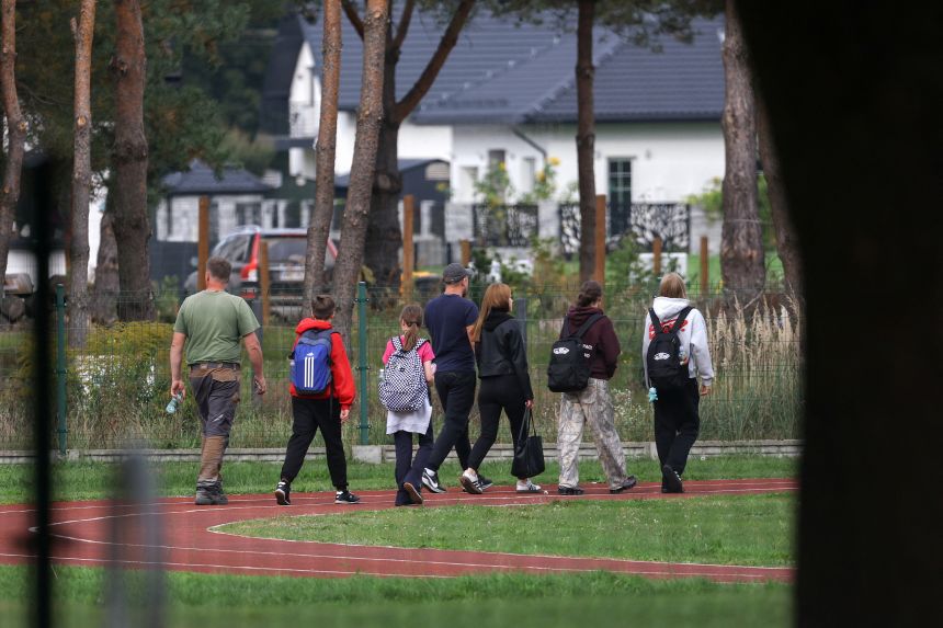 Parents walk with children at the site of a deadly attack at a school by a 15-year-old former pupil, in Leszczydol-Nowiny, Wyszkow County, northeast of Warsaw, Poland, October 8.