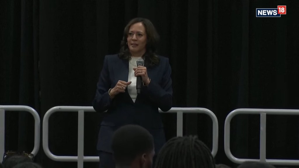 Kamala Harris speaking into a microphone during a campaign event.