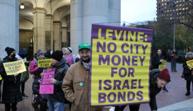 A member of District Council 37 holds a sign imploring incoming Comptroller Mark Levine not to invest the city