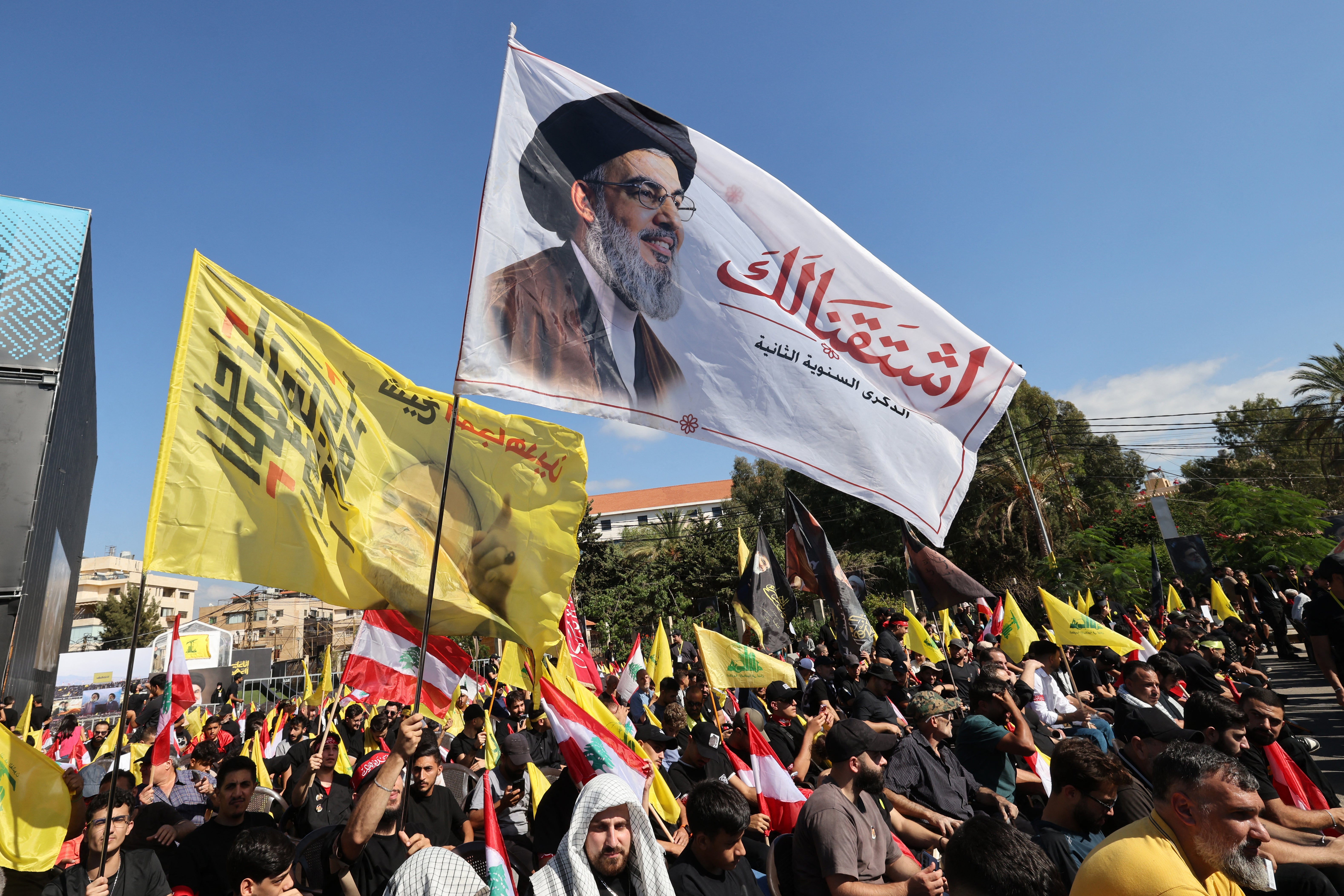 Supporters of Lebanese Shia movement Hezbollah hold up a flag bearing the image of slain leader Hassan Nasrallah during a ceremony held to mark the second anniversary of Nasrallah's killing in a strike by Israel, in Beirut's southern suburbs on September 27