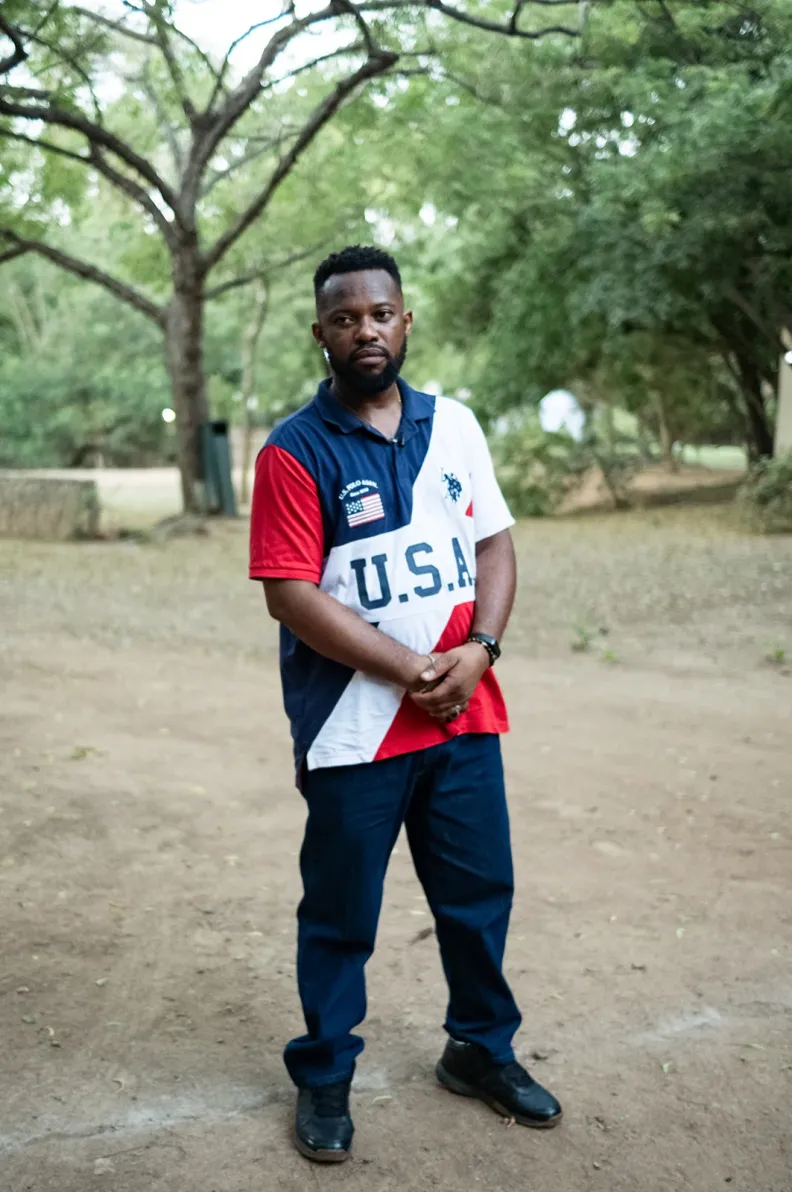 Samual Nmamdi holds his hands in front of him as he stands outside looking at the camera.