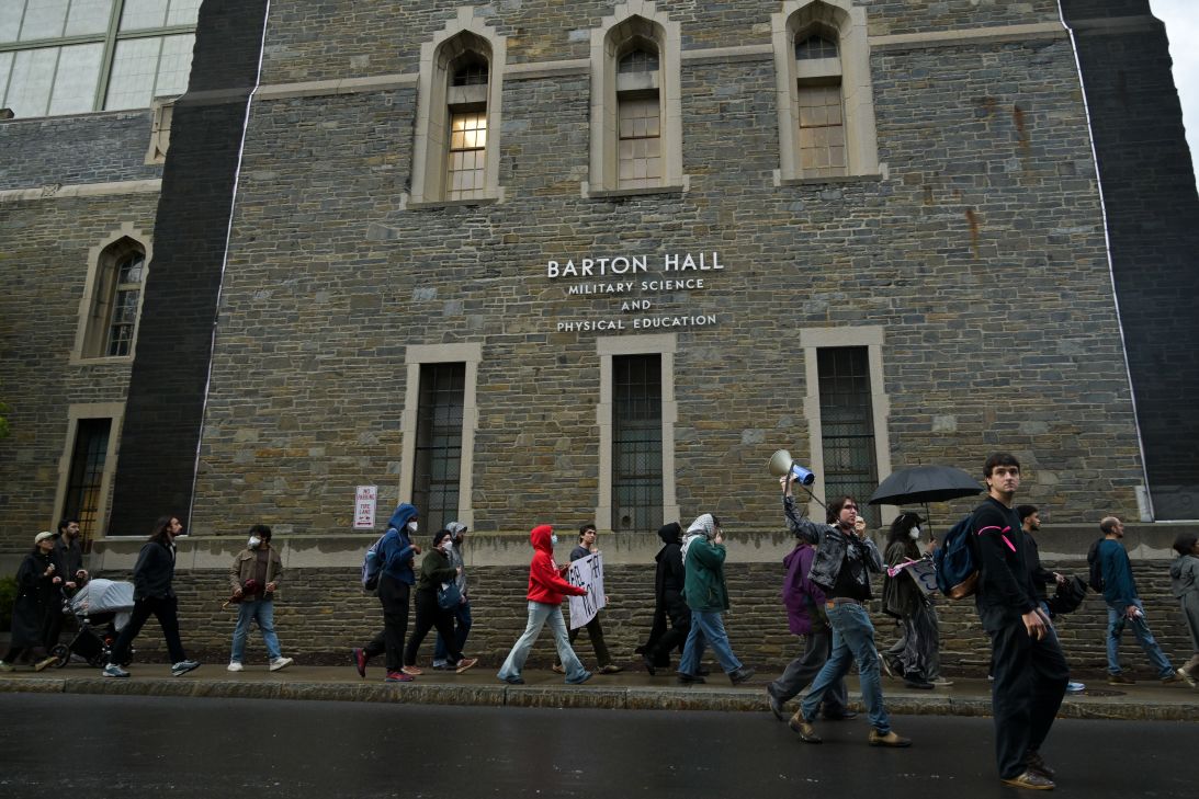Protesters march past Barton Hall, where the Cornell University police are headquartered, during a protest on Friday.