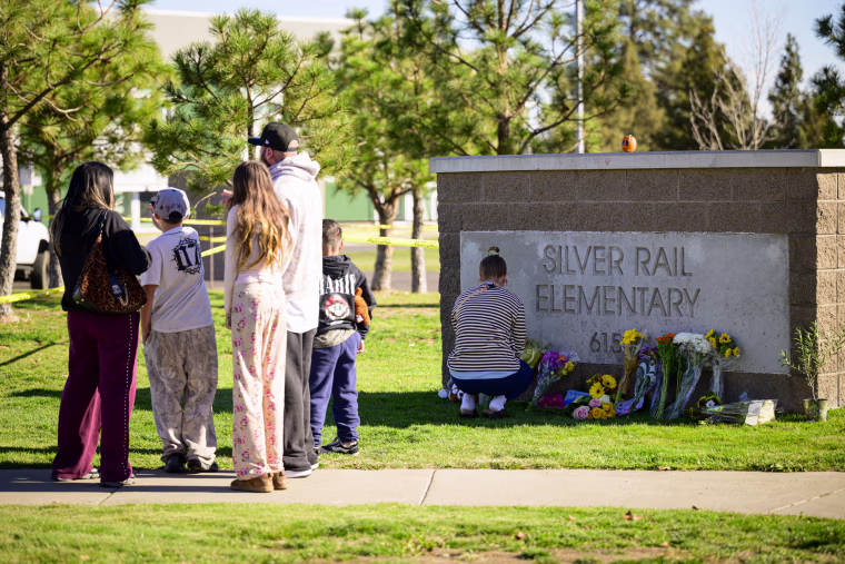 People pay tribute in front of Silver Rail Elementary School.