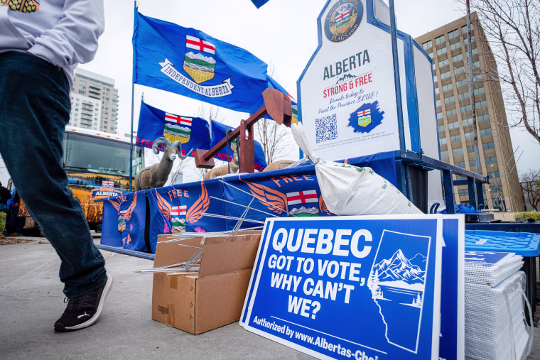 Image: A Alberta Independence rally, with a blue sign in the foreground that reads "Quebec got to vote, what can't we?".